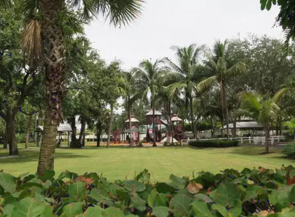 Tropical park with sky-high playground for older kids, toddler playground, fitness trail and stations, pale-lime gazebo, and spiffy basketball courts.