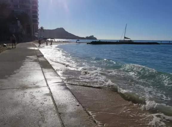 A partially paved path directly on the water that takes you in front of the grand hotels.