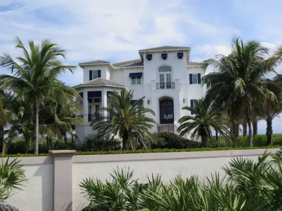 Walk along the sidewalk past mansions, tropical landscaping, and beautiful beach access points.