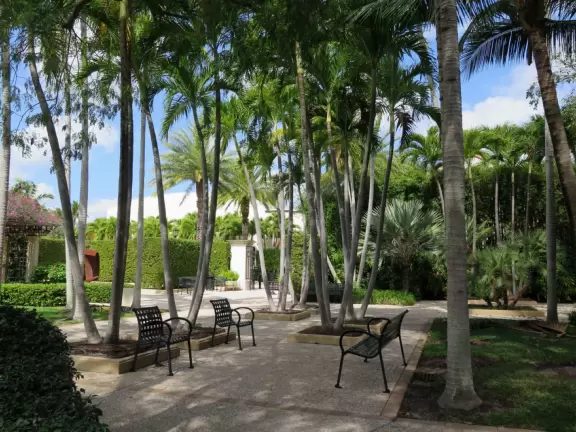 A tropical wonderland of palms, ferns, bromeliads, fountains, sculptures, rocks, ironwork gates, and pergolas, with the delightful scent of flowers filling the air.