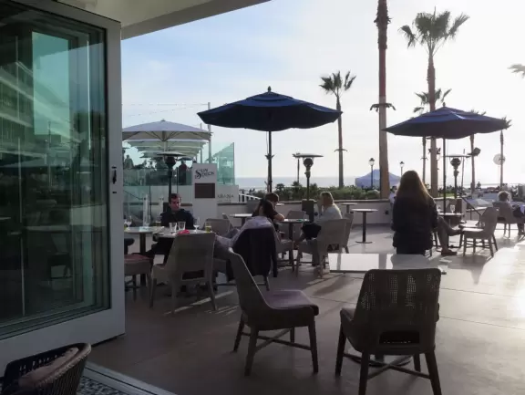 Historic resort with red turrets on foggy beach of fine white sand.