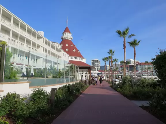 Historic resort with red turrets on foggy beach of fine white sand.