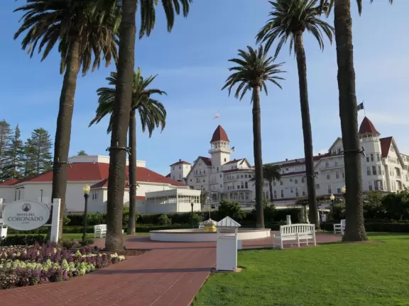 Historic resort with red turrets on foggy beach of fine white sand.