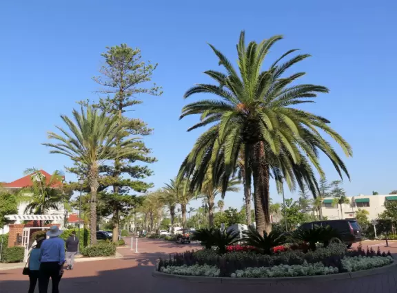 Historic resort with red turrets on foggy beach of fine white sand.