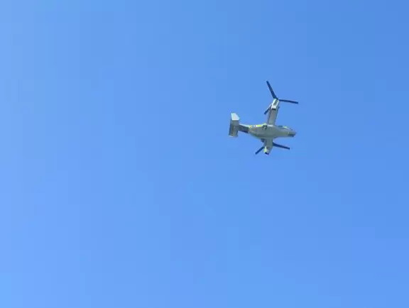 Historic resort with red turrets on foggy beach of fine white sand.