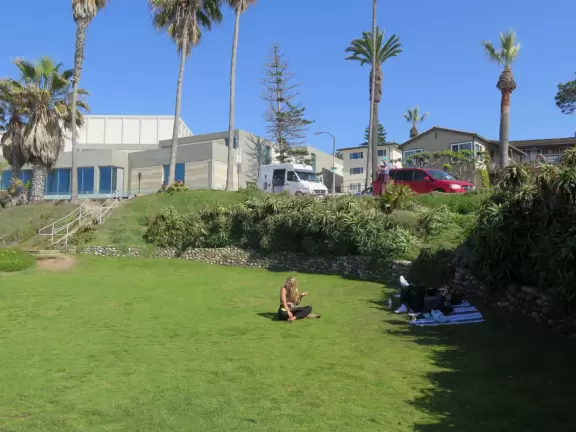 Lawn over cove with glorious views of clear, blue-green water. Nearby, gently-curved rocky outcroppings.