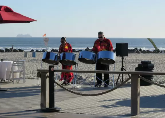 Historic resort with red turrets on foggy beach of fine white sand.