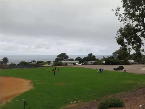 A friendly dog park, during certain&nbsp; hours, with slight views of ocean.