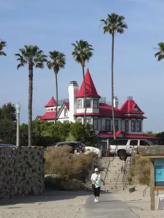 Historic resort with red turrets on foggy beach of fine white sand.