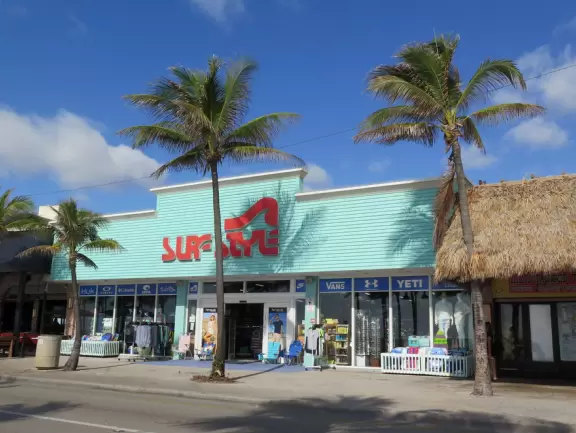 Thin strip of beach with shadeless boardwalk, white swirly wave wall, nice sand, unattractive people, and had-better-days condos.