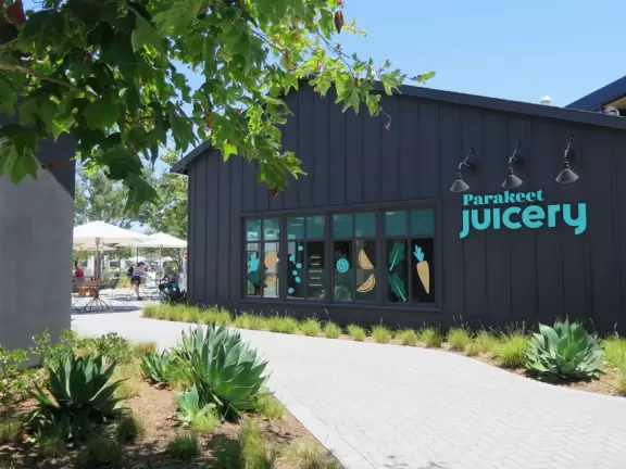 Upscale, colorful plaza in farmhouse style, with modern cafes. Kids climb on a huge log. The fire pit is fantastic at night, surrounded by eucalyptus trees.