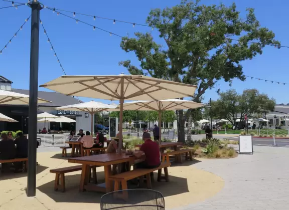 Upscale, colorful plaza in farmhouse style, with modern cafes. Kids climb on a huge log. The fire pit is fantastic at night, surrounded by eucalyptus trees.