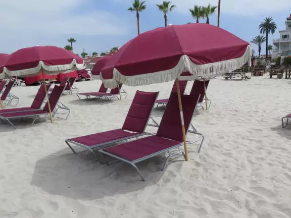 Historic resort with red turrets on foggy beach of fine white sand.