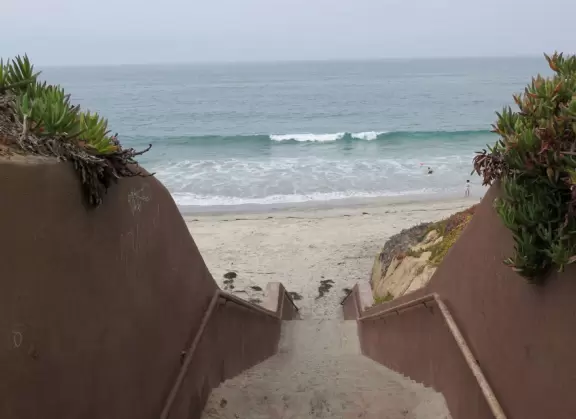 Gorgeous beach with steep steps leading down, and red cliffs like a national park!