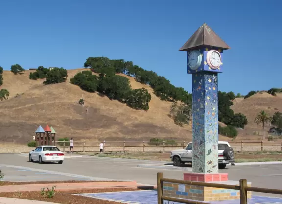 A wooden castle playground with gingerbread house, medieval towers, slides, bridges, monkey bars, rope bars, swings of all sorts, mist maker, viking ship, windmill, wild west town, rock-climbing wall, and tire swing.