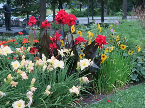 Impressive, stately building atop a hill, with lovely gardens and statues, and a fountain in the middle if the street.