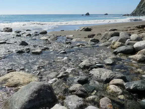 Beach that is like a dream! Crystal clear river leading to the ocean and huge white rocks.