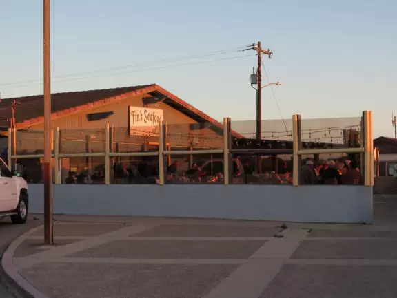 A glorious beach in Grover Beach town, with sand dunes and a wooden boardwalk, plus an octagon-shaped wooden pier in the sand.