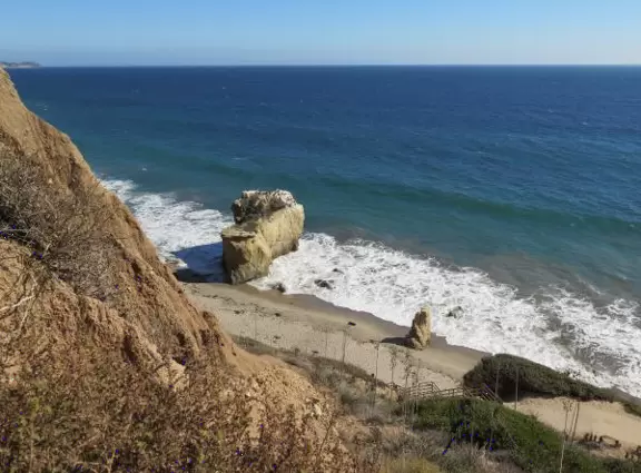 Incredible beach with blue-green water, rocks jutting out of the sea, arches, and caves.
