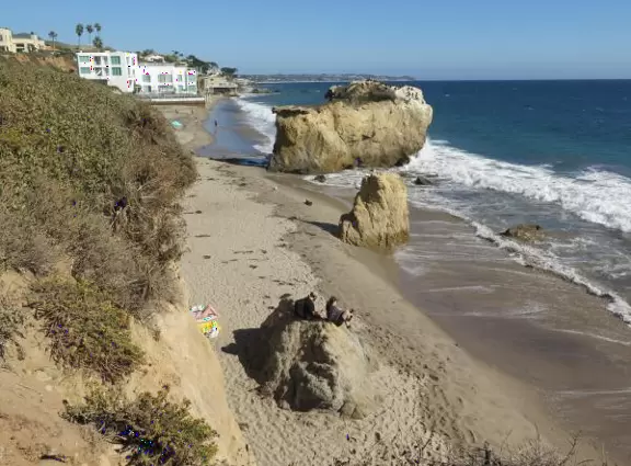 Incredible beach with blue-green water, rocks jutting out of the sea, arches, and caves.