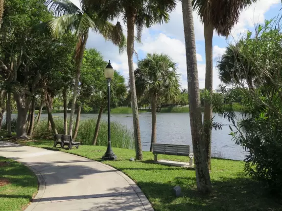 Playground by a lake with ibis birds, turtles, and a walking path.