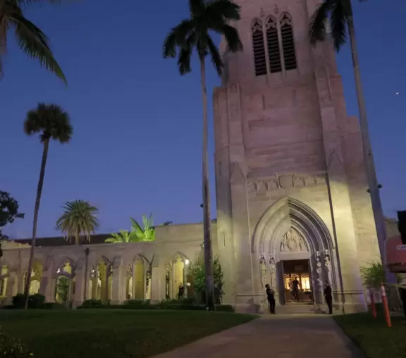 Delightful garden behind a gothic church, with lily pond, koi fish, tropical flowers, sculpted coral walls, fountain, and fresco.