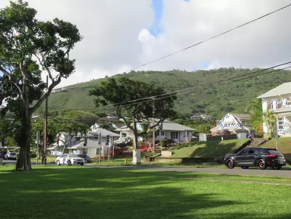 An older playground, tucked at the bottom of a hill, with huge wonderful trees.