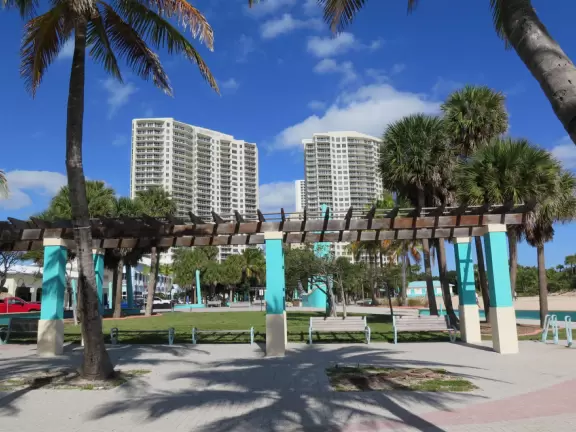 Beach with everything a beach should have: pale sand, aquamarine water, coconut palms, dunes, fit people, and cafes.