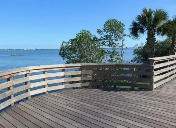 Popular 1.7 mile loop walking path with some shade and wooden boardwalk beside the river.