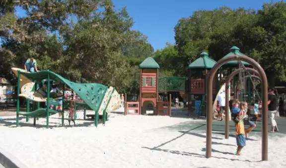A wonderfully shady park used for festivals, with a nice playground with net climby and a summer wading pool for little kids.