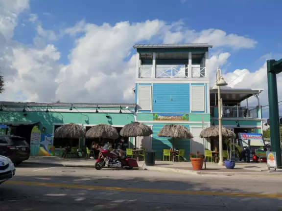 Main block with tropical-themed cafes and views of the water, plus a coffee shop and gift shops in little houses.