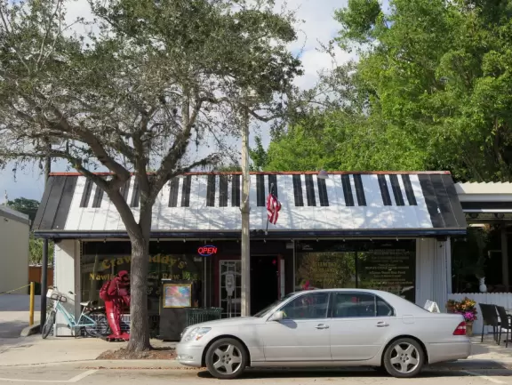 Main block with tropical-themed cafes and views of the water, plus a coffee shop and gift shops in little houses.