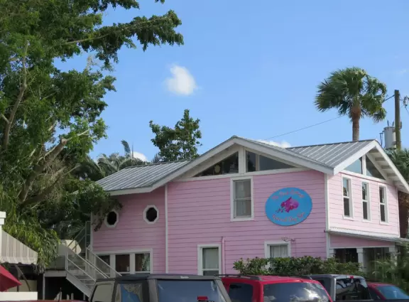 Main block with tropical-themed cafes and views of the water, plus a coffee shop and gift shops in little houses.
