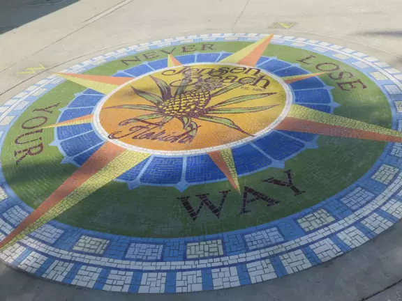 Main block with tropical-themed cafes and views of the water, plus a coffee shop and gift shops in little houses.