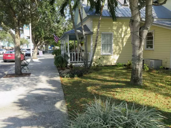 Main block with tropical-themed cafes and views of the water, plus a coffee shop and gift shops in little houses.
