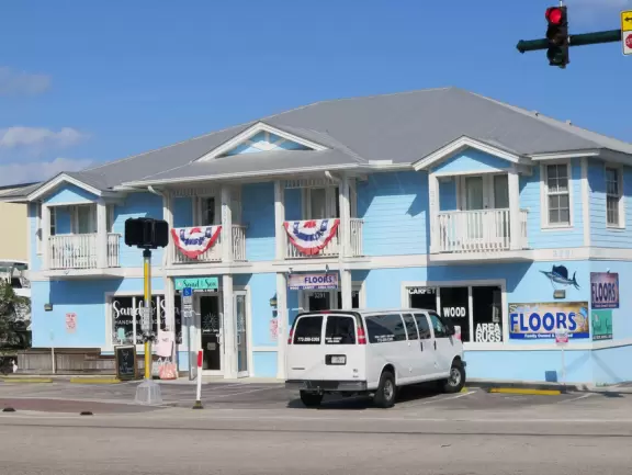 Main block with tropical-themed cafes and views of the water, plus a coffee shop and gift shops in little houses.