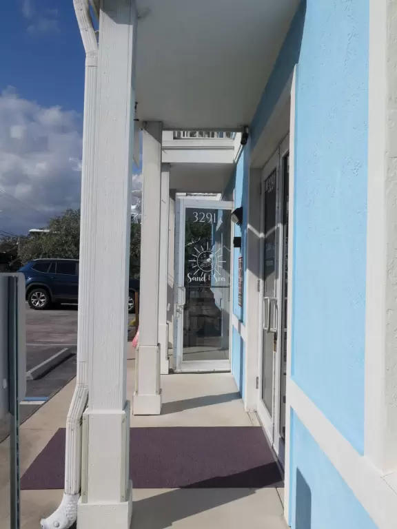 Main block with tropical-themed cafes and views of the water, plus a coffee shop and gift shops in little houses.