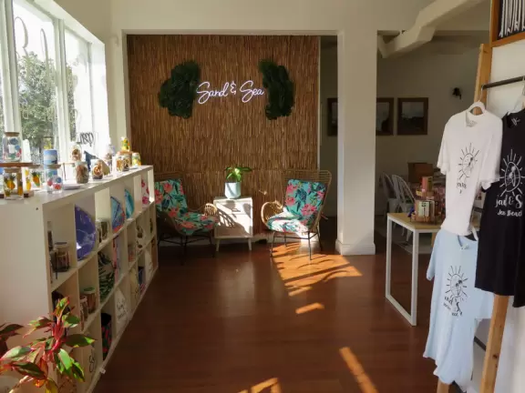 Main block with tropical-themed cafes and views of the water, plus a coffee shop and gift shops in little houses.