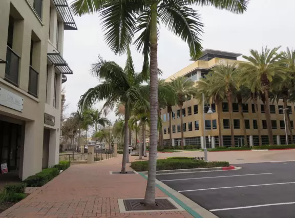 Street with shops and tiny coffee shop, and city views behind.