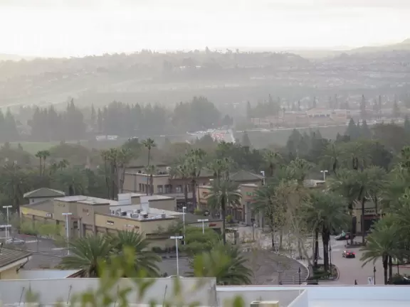 Street with shops and tiny coffee shop, and city views behind.