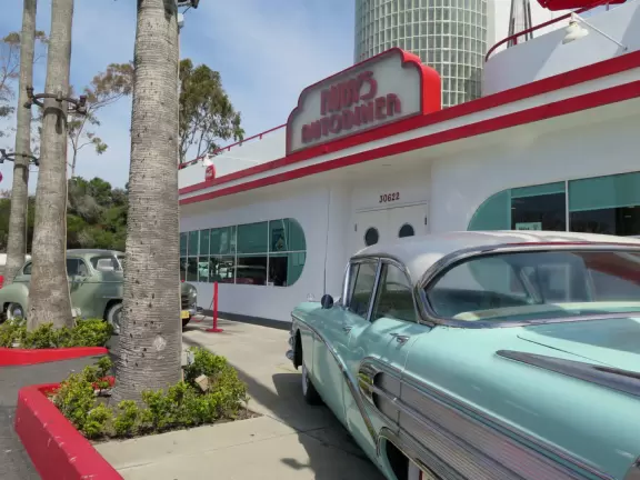 Sit on their rooftop patio under red umbrellas checking out the sea and the hills covered in tropical plants. Check out their 1950s cars and decor!
