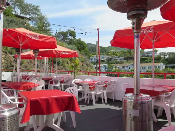Sit on their rooftop patio under red umbrellas checking out the sea and the hills covered in tropical plants. Check out their 1950s cars and decor!