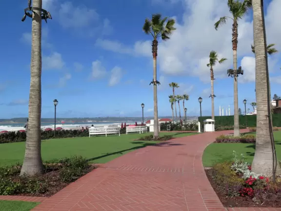 Historic resort with red turrets on foggy beach of fine white sand.