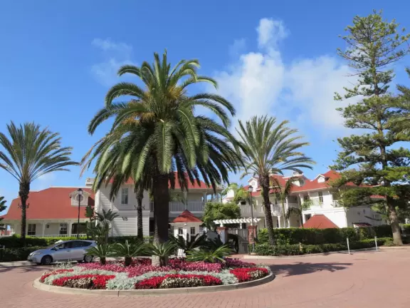 Historic resort with red turrets on foggy beach of fine white sand.