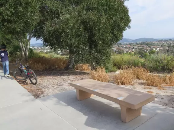 Large field with sweeping views, playgrounds, workout stations, picnic pavilions, and walking path around the field.