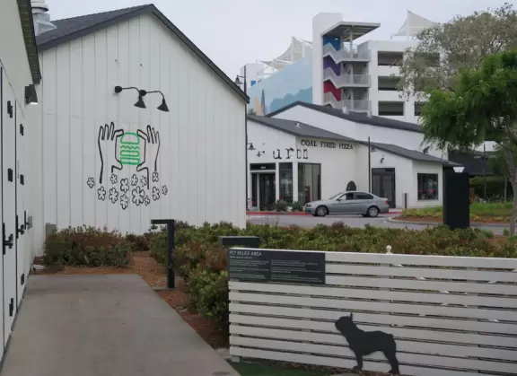 Upscale, colorful plaza in farmhouse style, with modern cafes. Kids climb on a huge log. The fire pit is fantastic at night, surrounded by eucalyptus trees.