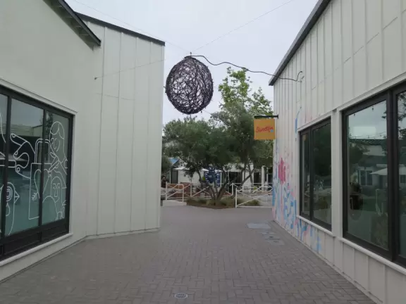 Upscale, colorful plaza in farmhouse style, with modern cafes. Kids climb on a huge log. The fire pit is fantastic at night, surrounded by eucalyptus trees.