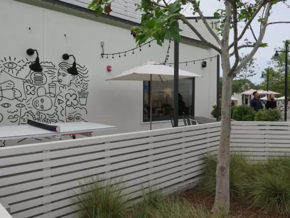 Upscale, colorful plaza in farmhouse style, with modern cafes. Kids climb on a huge log. The fire pit is fantastic at night, surrounded by eucalyptus trees.