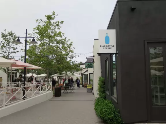 Upscale, colorful plaza in farmhouse style, with modern cafes. Kids climb on a huge log. The fire pit is fantastic at night, surrounded by eucalyptus trees.