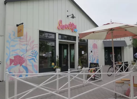 Upscale, colorful plaza in farmhouse style, with modern cafes. Kids climb on a huge log. The fire pit is fantastic at night, surrounded by eucalyptus trees.